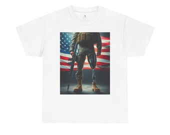 May include: A white t-shirt with a graphic of a soldier standing in front of an American flag. The soldier is wearing camouflage pants and a black vest. He is holding a rifle in his right hand and has a prosthetic leg.