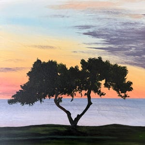 Puede incluir: Una pintura al óleo representa un árbol con un tronco en forma de corazón contra un cielo al atardecer. El cielo transiciona de naranja a azul, con indicios de nubes. El follaje verde oscuro del árbol contrasta con el fondo colorido, y se ve el mar.