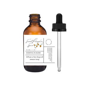 May include: A brown glass bottle with a white label that reads "Sweet Pumpkin Spice" and "Essential Oil Blend". The label also says "Diffuse a few drops all season long!" and lists the ingredients: vanilla essential oil, cardamom essential oil, nutmeg essential oil, and cinnamon bark essential oil. The bottle has a black dropper cap.
