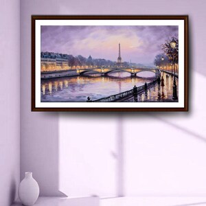 May include: A framed painting depicts a Parisian cityscape at dusk. The Eiffel Tower is visible in the distance, with a bridge and buildings along the river. The artwork features a dark brown frame and a soft, purple and gold color palette.
