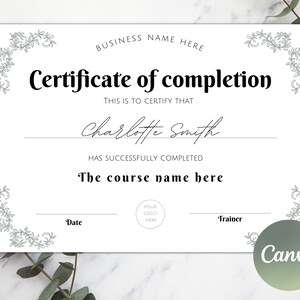 Puede incluir: Un certificado blanco de finalización con un borde negro y diseños florales en las esquinas. El texto "Certificado de finalización" está en negrita negra. El texto "Esto es para certificar que" está en negro. El nombre "Charlotte Smith" está escrito a mano en tinta negra. El texto "Ha completado con éxito" está en negro. El texto "El nombre del curso aquí" está en negro. Los textos "Fecha" y "Entrenador" están en negro. El texto "Su logotipo aquí" está en negro.