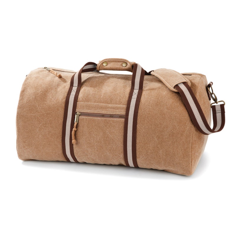May include: A tan canvas duffel bag with brown and white striped straps. The bag has a zippered pocket on the front and a top handle.