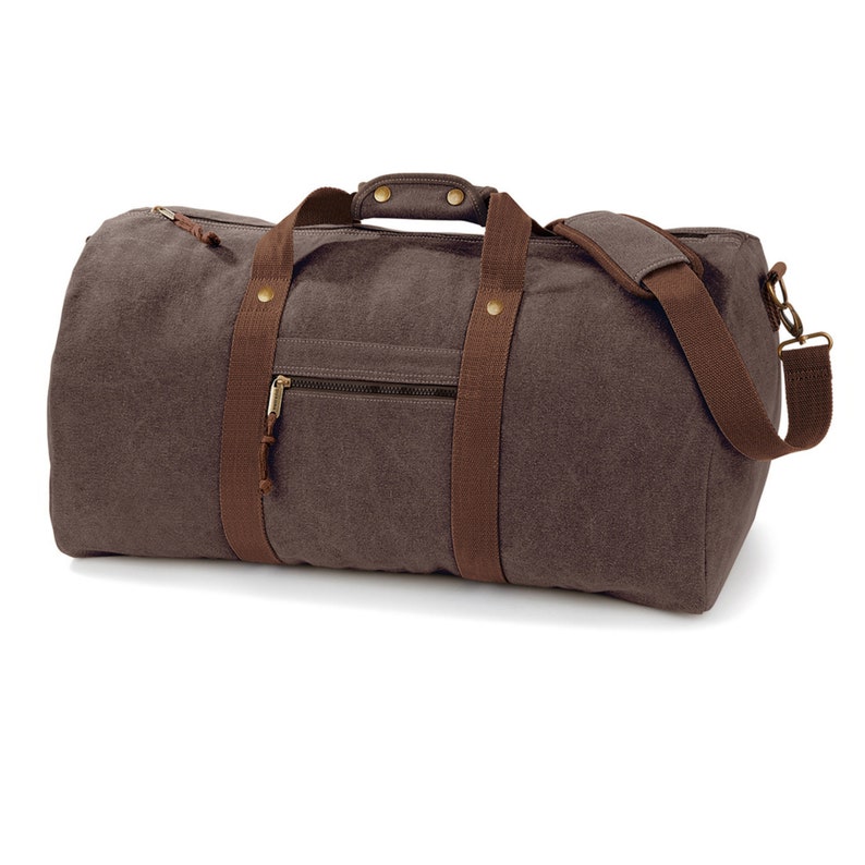 May include: A brown canvas duffel bag with brown leather straps and brass hardware. The bag has a zippered pocket on the front.