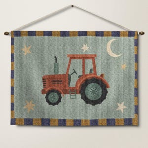 May include: A wall hanging featuring a red tractor illustration on a light blue background. The design includes a crescent moon and stars. The border has a blue and gold checkered pattern. The wall hanging is suspended from a wooden rod.