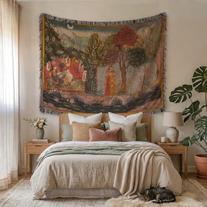 May include: A bedroom with a tapestry depicting a landscape scene above a bed. The bed has a light-coloured duvet, pillows, and a green throw. A cat rests on a rug near the bed. Wooden bedside tables and a potted plant complete the scene.