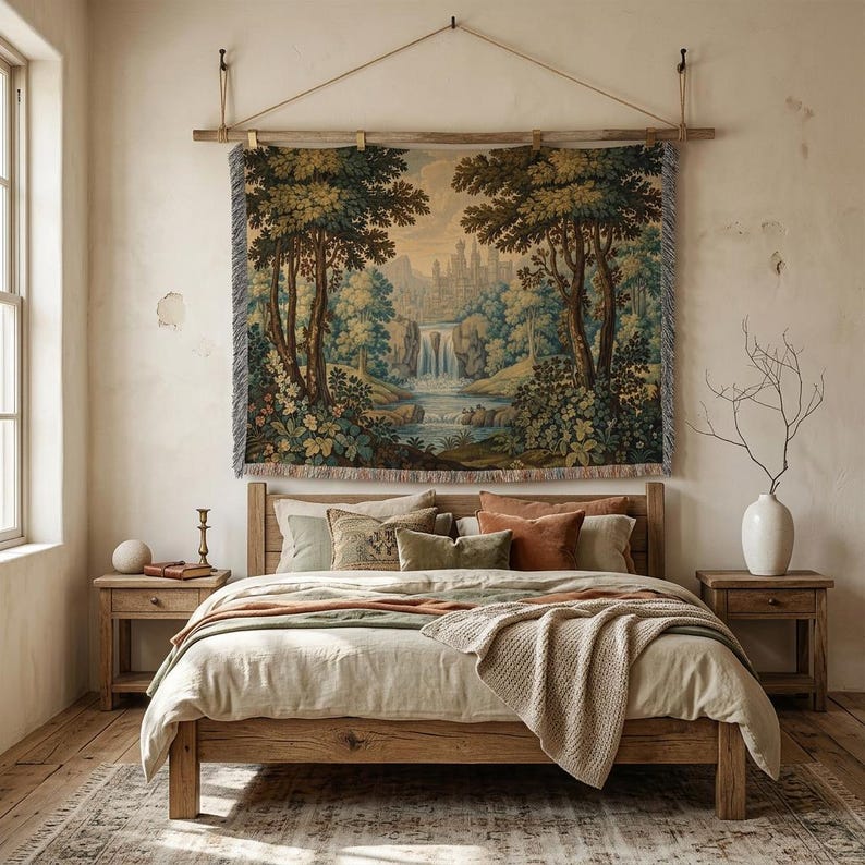 May include: A bedroom scene featuring a wooden bed frame, nightstands, and a large tapestry depicting a landscape with a waterfall. The bed is made with neutral-toned bedding and decorative pillows. A vase with branches and a candle holder are on the nightstands.