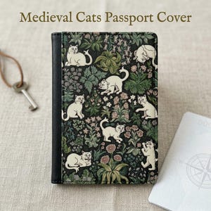 Op de afbeelding: Zwarte paspoorthoes met een patroon van katten en bloemen. Het ontwerp toont witte katten tussen groene bladeren en roze bloemen. De tekst "Medieval Cats Passport Cover" staat bovenaan.