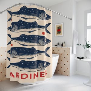 May include: A beige shower curtain featuring a repeating pattern of stylized navy blue fish with white dots. The word "ARDINES" is printed in red at the bottom. The curtain is hanging in a bathroom.