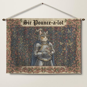 May include: A wall tapestry featuring a cat in knight's armor holding a mouse. The tapestry has a floral background and a decorative border. The text "Sir Pounce-a-lot" is at the top. The tapestry is hung from a wooden rod.