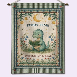 May include: A wall hanging with a whimsical design. It features a green dinosaur reading a book, with the words "Story Time" and "Snuggle Up & Read". The design includes floral and celestial elements, with a striped border. The overall theme is reading.