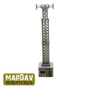 Può includere: Una miniatura grigia di torre radio con struttura a traliccio, antenna e una piccola base di edificio. La torre è un modello dettagliato per hobbisti e collezionisti. Il logo "MARDAV MINIATURES" è in un rettangolo verde e giallo.