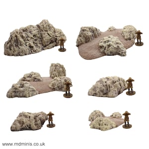 Op de afbeelding: Zes verschillende miniatuur woestijnrotsformaties voor tabletop gaming. De rotsen zijn gemaakt van een lichtbruin materiaal en zijn getextureerd om eruit te zien als echte rotsen. Elke rotsformatie is ongeveer 5-7,5 cm hoog en breed.