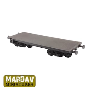Puede incluir: Un vagón plano en miniatura gris con ruedas negras y una superficie texturizada. El modelo tiene forma rectangular y está diseñado para juegos de mesa o modelismo ferroviario. El logotipo "MARDAV MINIATURES" es visible.