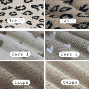 May include: Six fabric swatches are shown in a close-up view. Two swatches display a leopard print, labelled "leo 1" and "leo 2". Two swatches have a heart pattern, with the text "Herz 1" and "Herz 2". The final two swatches are solid, labelled "taupe" and "beige".