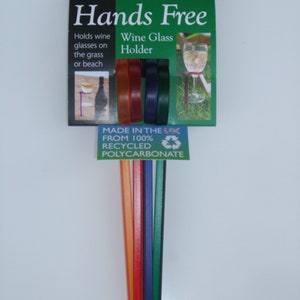 May include: Set of six colorful plastic wine glass holders. The holders are made from 100% recycled polycarbonate and are designed to hold wine glasses securely in the ground. The packaging says "Hands Free Wine Glass Holder".
