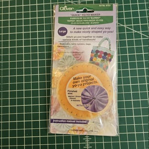 May include: A Clover brand large Quick Yo-Yo Maker in its original plastic packaging. The packaging features the text "QUICK YO-YO MAKER," "Large," and "Make your own original yo-yo projects." It indicates a finished size of 45mm in diameter.