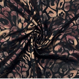 May include: Black fabric with a gold and brown leopard print pattern.