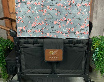 May include: Black wagon with a floral canopy and a brown patch with the text "Summer" on the front. The wagon has two large wheels and a smaller wheel on the back.