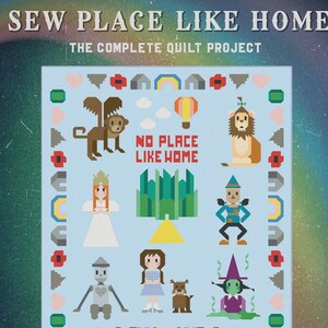May include: A light blue quilt project featuring pixelated illustrations of characters and elements from The Wizard of Oz. The text "SEW PLACE LIKE HOME" and "NO PLACE LIKE HOME" are displayed. The quilt is a complete project from Art East Quilting Co.