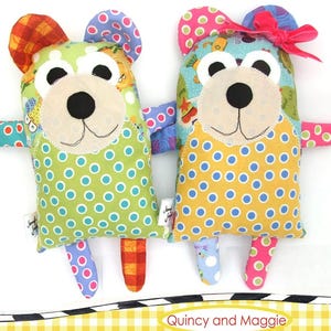 May include: Two handmade bear-shaped plush toys with colorful patterned fabric. One bear is green with blue polka dots, the other is yellow with blue polka dots. The bears have black button eyes, a beige muzzle, and the text "Quincy and Maggie". The brand name "Jennifer Heynen Creative Co." is also visible.