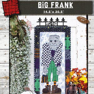 May include: A Halloween-themed fabric wall hanging featuring a Frankenstein's monster design. The artwork is framed with a black border and includes the text "BIG FRANK" and dimensions of 14.5" x 30.5". The design incorporates green, black, white, and orange colors.