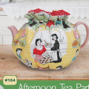 May include: A decorative teapot cozy with a pink handle and spout, featuring a yellow checkered pattern with retro illustrations of women baking. The top is covered with a red and green patterned fabric. The text "Afternoon Tea Party" is visible.