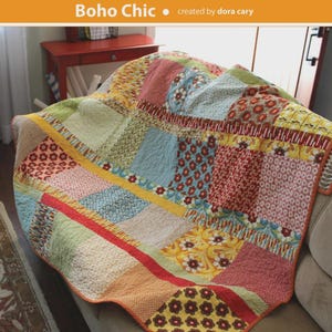 May include: A patchwork quilt in the "Boho Chic" style, featuring squares of various patterns and colors, including floral and geometric designs. The quilt measures 64" x 70" and is draped over a sofa. The text "Orange dot Quilts" and "Boho Chic" are visible.