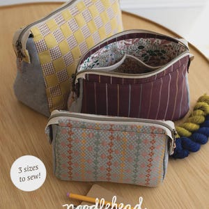 May include: Three fabric pouches in different sizes with zipper closures. The largest pouch has a yellow and white checkered pattern, the middle one has a burgundy striped pattern, and the smallest has a multi-colored woven pattern. The text "PLOVER POUCH" is at the top.