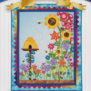 May include: A quilt titled "Spectacular Summer" featuring a colorful floral design with sunflowers, bees, and a beehive. The quilt has a blue background and a decorative border. The text "Full-size diagrams included!" is also present.