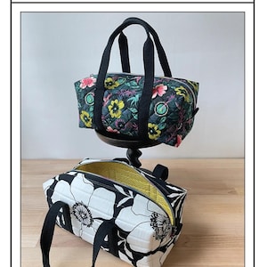 May include: Two mini duffle bags with black handles. One bag features a floral pattern with pink, yellow, and green flowers on a dark background. The other bag has a black and white floral design. The text "Simple Mini Duffle" is at the bottom.