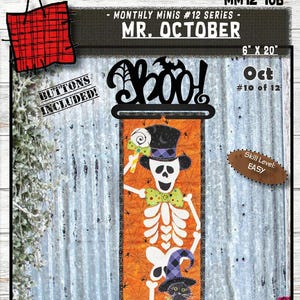 May include: A Halloween-themed fabric panel featuring a skeleton with a top hat and a black cat wearing a witch hat. The panel is orange with spiderwebs and the text "Boo!" and "Mr. October". The panel measures 6" x 20".