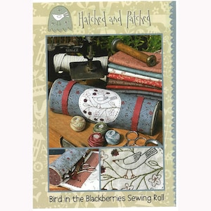 May include: A sewing roll with a blue and red fabric exterior and a white embroidered bird design. The roll is labeled "Bird in the Blackberries Sewing Roll" and is part of the "Hatched and Patched" collection.