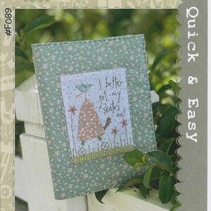 May include: A notebook cover with a floral pattern in shades of green and white. The cover features a central image with a whimsical illustration of a character on skates, accompanied by the text "I better get my skates on!" The cover is labeled "Put My Skates On Notebook Cover".