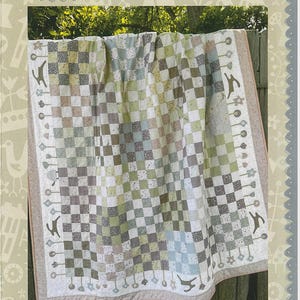 May include: A handmade quilt with a checkerboard pattern in shades of green, gray, and white. The quilt features a border with decorative elements and the text "Hatched and Patched" and "Around the Mulberry Bush".