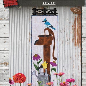May include: A rustic quilt panel featuring a brown water pump with a blue bird perched on top. The panel includes the text "OLE' RUSTY PUMP" and measures 12" x 33". The design incorporates flowers and a watering can, with an easy skill level.