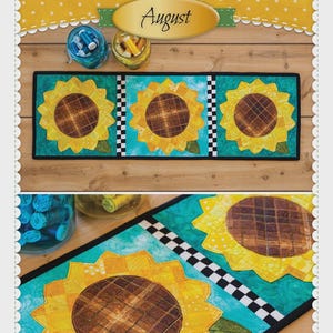May include: Patchwork accent runner featuring three large sunflowers with yellow petals and brown centers, set against a turquoise background. The runner includes black and white checkered accents and the text "Sunflowers August".