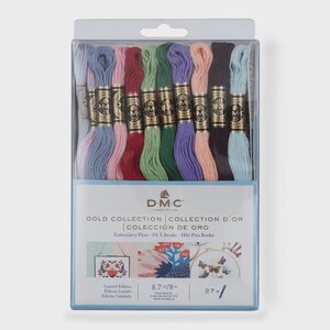 May include: A D.M.C. Gold Collection embroidery floss set in a clear plastic package. The set contains 27 skeins of thread in various colors including light blue, pink, red, green, purple, peach, and dark brown, each labeled 8.7 yd/8 m.