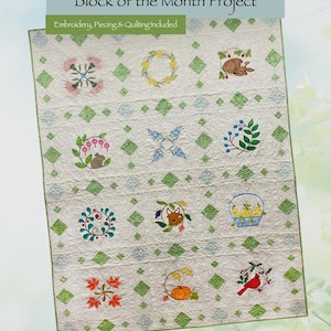 May include: A white quilt with embroidered floral and animal designs, including a squirrel, bird, and fox. The quilt features a green diamond pattern and the text "Peaceful Garden Block of the Month Project". The quilt is a design by Amélie Scott.