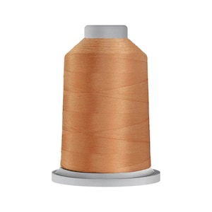May include: A spool of peach-colored thread on a white plastic bobbin.