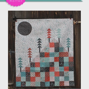 May include: A quilted wall hanging with a mountain scene. The design features a black circle, representing the sun, and trees atop a mountain made of red, teal, and black squares. The quilt measures 54" x 63".