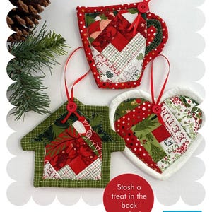 May include: Handmade Christmas ornaments in the shape of a mug, house, and heart. Each ornament is made of patchwork fabric in red, green, and white. The mug is 5.5 inches wide and 5 inches high. The ornaments have red ribbon loops and button accents.
