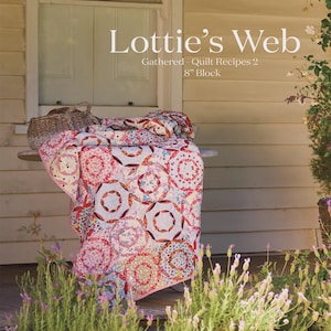 May include: A colorful quilt with a circular pattern, draped over a small table. The quilt features red, pink, and white fabrics. The text "Lottie's Web" and "Gathered - Quilt Recipes 2 8" Block" are visible. The image also includes the text "Acrylic Templates Only".