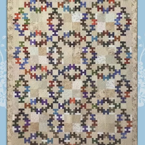 May include: A quilt with a repeating geometric pattern in shades of beige, brown, blue, red, and purple. The quilt features the text "Summer Wedding" in a decorative font. The design is by Jamie Janow Elfert and created by Black Cat Creations.