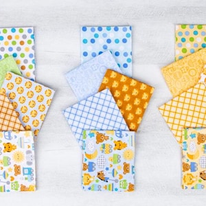 May include: A set of 10 fabric squares with various patterns, including blue and yellow polka dots, checkered patterns, and animal prints. The fabric squares are arranged in three rows, with three squares in each row.