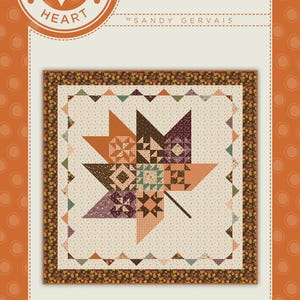 May include: A quilt pattern titled Pieces From My Heart #824 Pressed Leaves by Sandy Gervais. The design features a central maple leaf motif composed of various small patchwork squares in autumn colors, surrounded by a cream border with small dots.