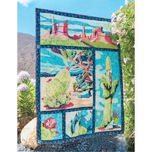May include: A colorful quilt featuring desert landscape scenes. The quilt showcases images of cacti, rock formations, and desert plants in shades of green, blue, and orange. The quilt is bordered with a dark blue fabric.
