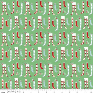 May include: A green fabric with a repeating pattern of red and white striped stockings, blue socks, and red stockings with holly sprigs.
