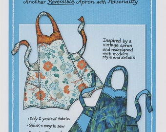 May include: A blue and white pattern for a Chatterbox Apron Pattern by Mary Mulari Designs. The pattern features two apron designs, one with floral patterns and the other with a blue leaf pattern. The text says "Another Reversible Apron with Personality."