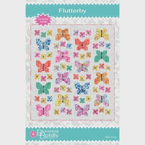 May include: A fabric panel with a butterfly quilt design. The quilt features colorful butterflies in shades of blue, orange, pink, yellow, and green, set against a light gray background. The text "Flutterby" is at the top, with "Fat Quarter Friendly" and "Blooming Boldly Designs" also visible.