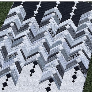 May include: A modern French Braid quilt titled "Icicles" in shades of black, white, and gray. The quilt features a geometric design with a repeating chevron pattern. The quilt is made by Amanda Murphy.